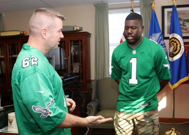 PICATINNY ARSENAL, N.J. - Maj. Gen. John T. Reim, Joint Program Executive Officer (JPEO) Armaments and Ammunition and Senior Commander of Picatinny (right) presents a challenge coin to Staff Sgt. Michael C. Graves (right) after he reenlists in the...