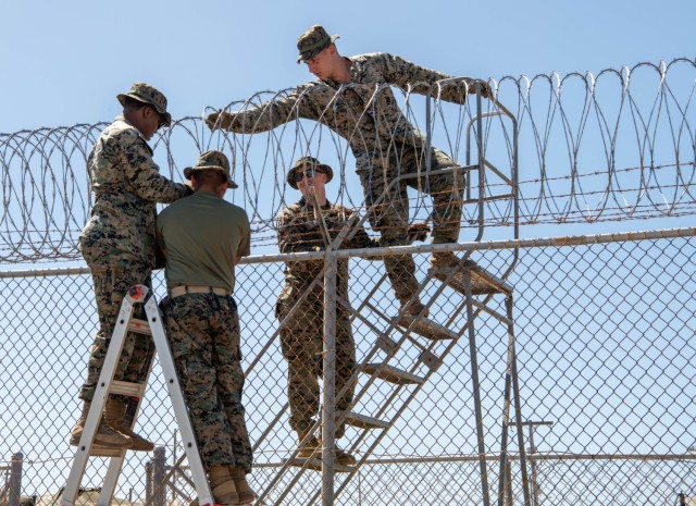 250208-N-JO823-1028 GUANTANAMO BAY, Cuba (February 8, 2025) U.S. Marines set up razor wire in support of the Department of Defense and Department of Homeland Security mission to expand the Illegal Alien Holding Operations Center during Operation...