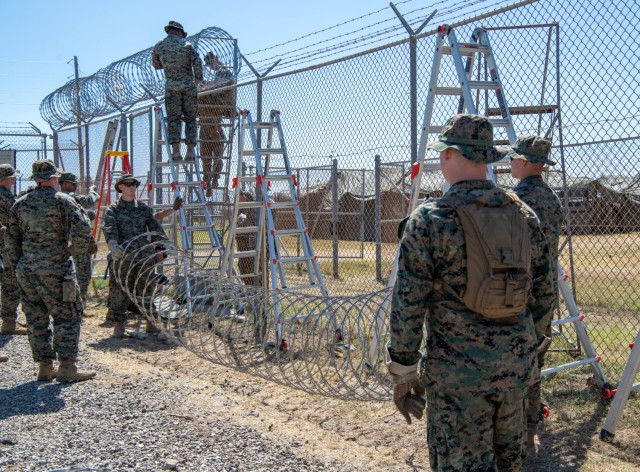 250208-N-JO823-1006 GUANTANAMO BAY, Cuba (February 8, 2025) U.S. Marines set up razor wire in support of the Department of Defense and Department of Homeland Security mission to expand the Illegal Alien Holding Operations Center during Operation...