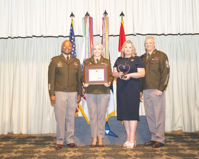 Four people stand side by side, posing for a picture.