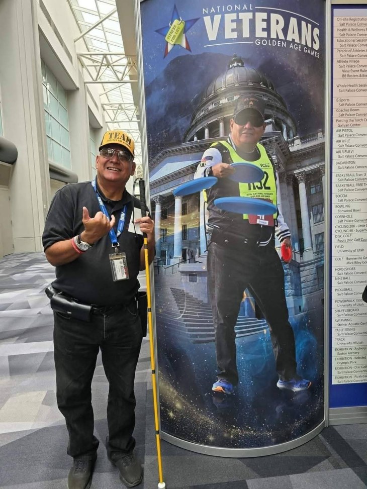 Pic of veteran posing near his photo banner