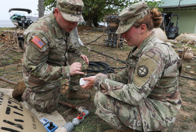 Spc. Colton Hines, left, and Sgt. Jessica Shields, water purifications specialist with the 935th Aviation Support Battalion, Missouri Army National Guard, checks the chlorine levels of the water meant for cooking and cleaning laundry during...