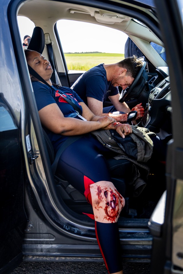 Simulated casualties await first responders at the scene of a staged vehicle collision during an emergency services exercise in Powidz, Poland, May 15, 2024. Role players wear moulage—realistic mock injuries and fake blood—to help emergency...