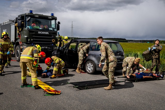U.S. Army medics from the 162nd Medical Company – Area Support, a Polish military medic from the 33rd Air Base, and firefighters from the State Fire Service (Państwowa Straż Pożarna) arrive at the site of a simulated vehicle collision during...