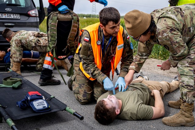 Polish Army Pvt. Piotr Maciejewski of the 33rd Air Base and U.S. Army Spc. Brenda Cabrera of the 162nd Medical Company – Area Support assess a simulated casualty during an emergency services exercise in Powidz, Poland, May 15, 2024. Despite a...
