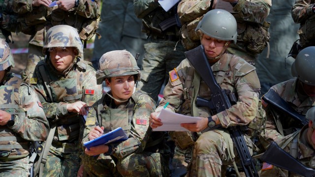 Officer Candidates from the New Jersey and New York Army National Guard copy notes during an operation order brief during a field training exercise in Rreth-Greth, Albania.