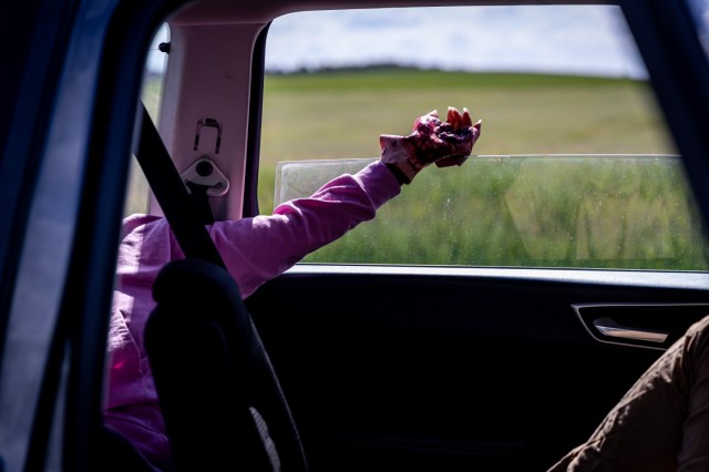 A moulaged hand belonging to one of the role players hangs from a vehicle window during a staged crash scenario in an emergency services exercise in Powidz, Poland, May 15, 2024. The realistic injuries and visual effects enhance the training...