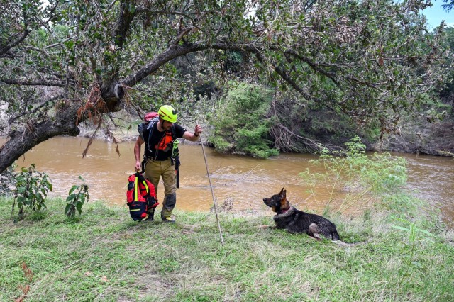 Matej Bartosik, a search and rescue dog  handler with a Czech Republic emergency response team, or CZERT, works alongside his search-and-rescue dog Bart during flood response operations near Sisterdale, Texas, July 18, 2025. The Czech team...