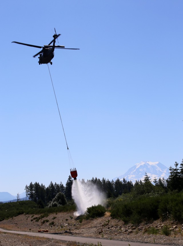 A UH-60 Blackhawk Helicopter from Charlie Company, 1st Battalion, 140th Aviation, 96th Troop Command, Washington Army National Guard conducts water bucket training with Central Pierce Fire and Rescue, June 30, 2025, near Puyallup, Wash.