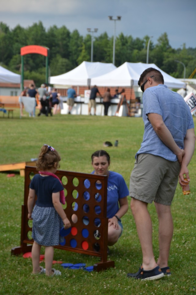 A Family plays a large version of Connect Four outside during a festival.