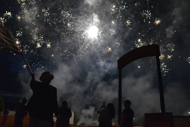 A man in a straw hat waves an American flag.
