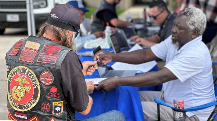 Veteran wearing motorcycle vest with Marine Corps eagle, globe and anchor emblem.