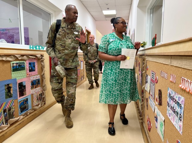 Maj. Gen. James Smith, acting commander of U.S. Army Installation Management Command, and Alicia Exum, program operations specialist for Child and Youth Services,  wave hello to kids at U.S. Army Garrison Italy’s Child Development Center during...