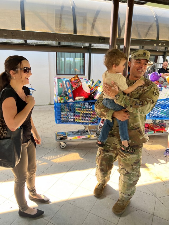 CSM Ricardo Moreno holds the youngest recipient, Aedyn, in the "Pre-Reader" category while his mom watches.